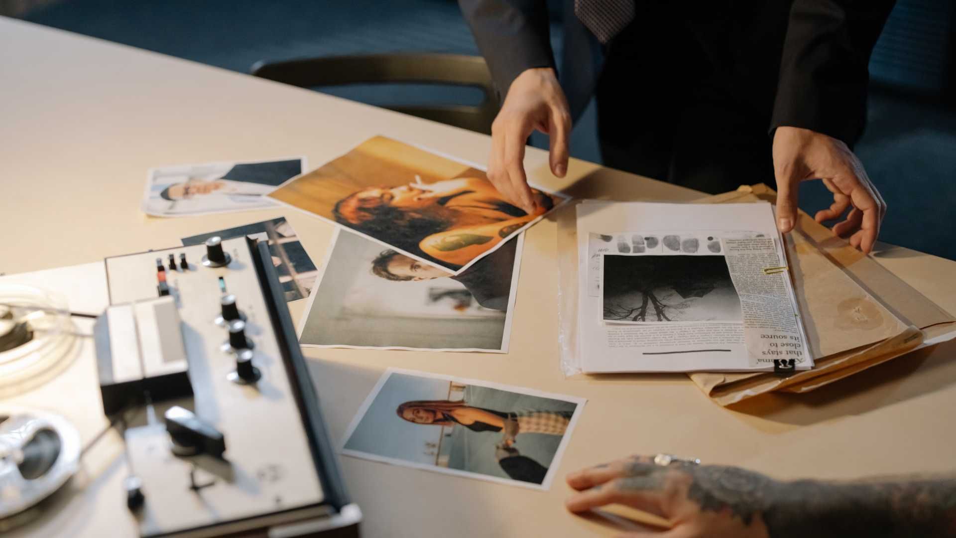 A couple of people are sitting at a table looking at pictures.
